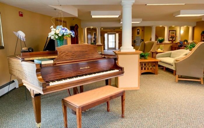 A cozy living room with a piano and comfortable seating.