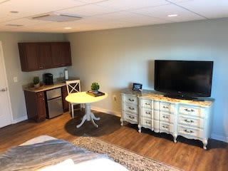 A cozy studio apartment with a kitchenette and TV area.