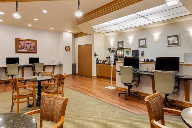 A modern office workspace featuring computers, chairs, and tables.