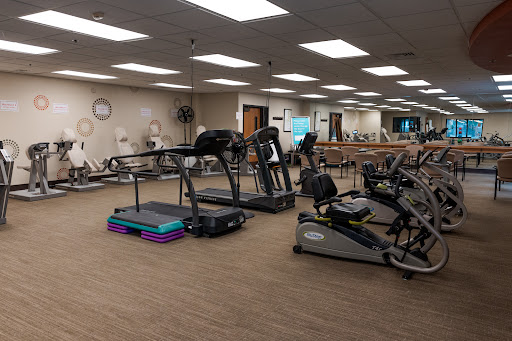 A view of a fitness center featuring various exercise machines, including treadmills and other workout equipment.