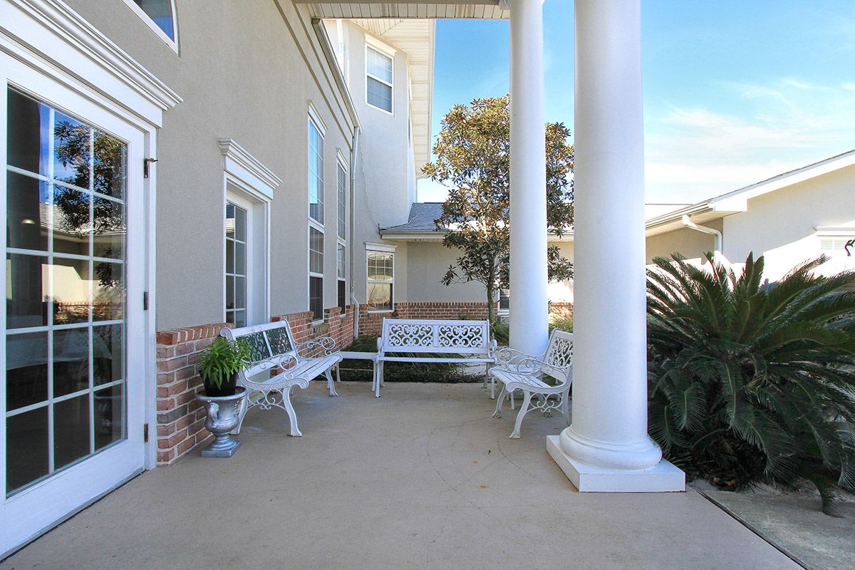Sunny porch with benches and decorative columns.