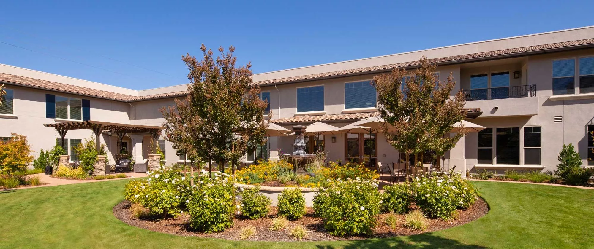 A two-story residential house with a well-maintained garden and landscaping.