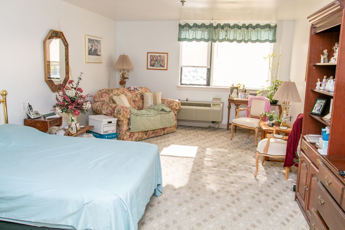 A cozy bedroom with a bed, sofa, and decorative elements.