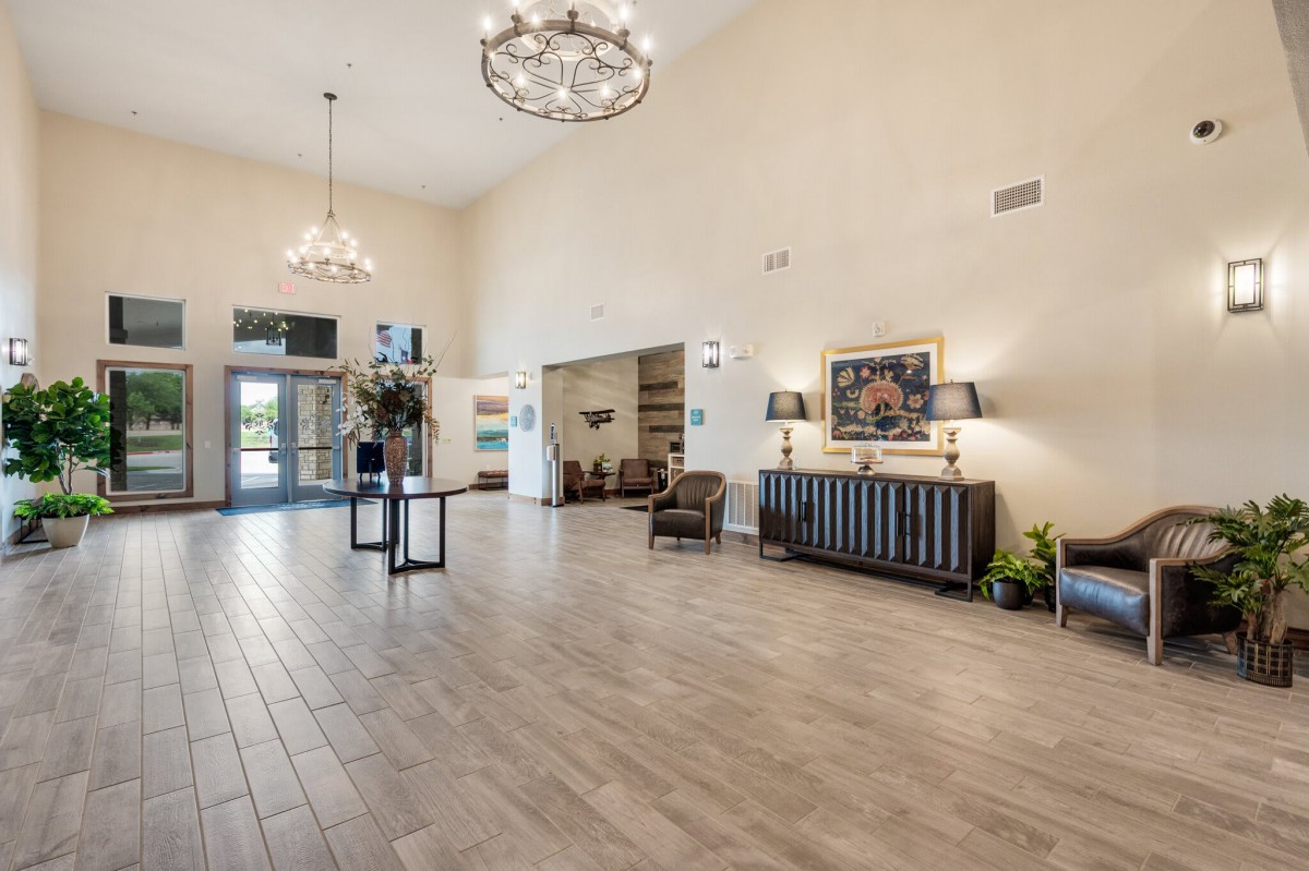 A spacious and elegantly decorated lobby with chandeliers and comfortable seating.