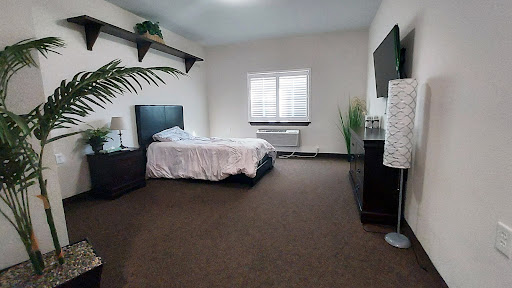 A modern and cozy bedroom featuring a neatly made bed, minimalist furniture, and natural light.