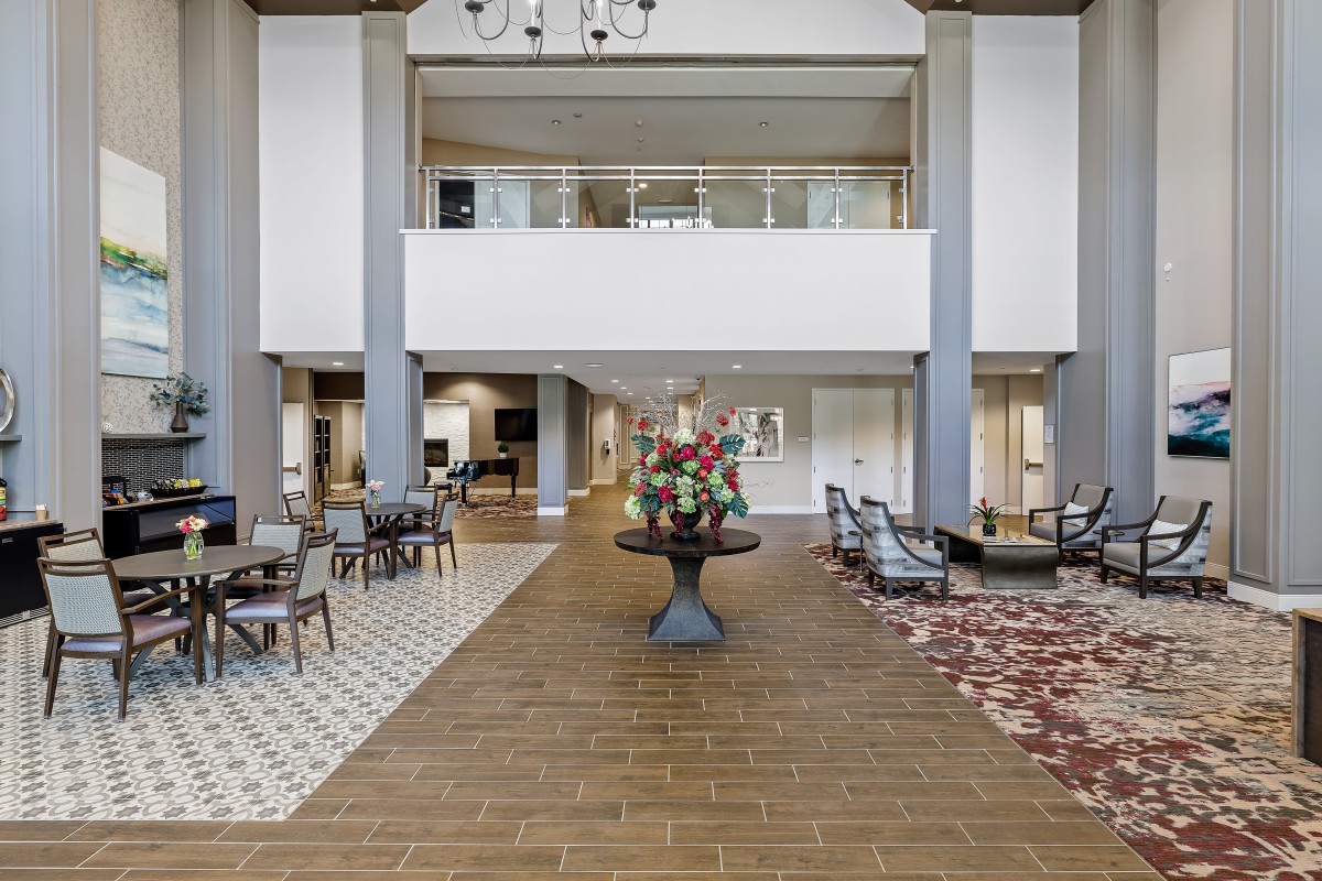 Elegant hotel lobby with seating areas and floral centerpiece.