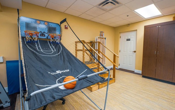 An indoor basketball arcade game set up in a recreation room.