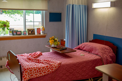 A cozy bedroom setting featuring a neatly made bed with decorative bedding, a tray for convenience, and a cheerful bouquet of flowers on display.