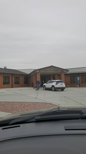 A view of a residential building on a cloudy day with a parked white car.