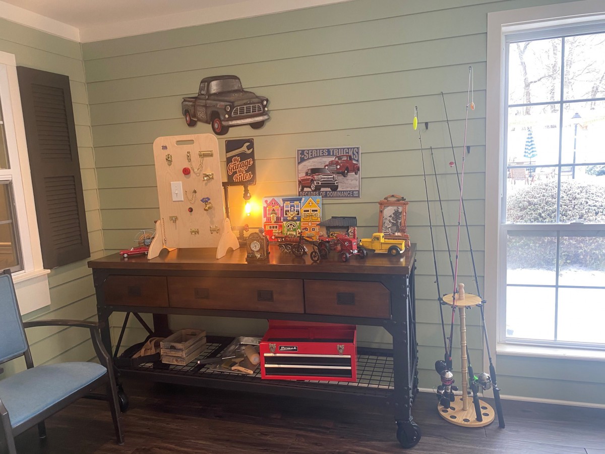 A cozy corner featuring a vintage-themed console table with toy collectibles and fishing rods.