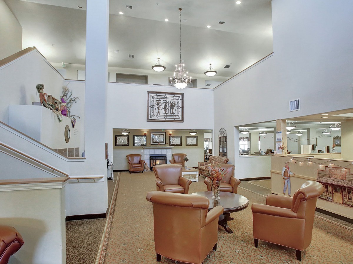 A spacious lobby featuring leather chairs, modern chandeliers, and a stylish open design.