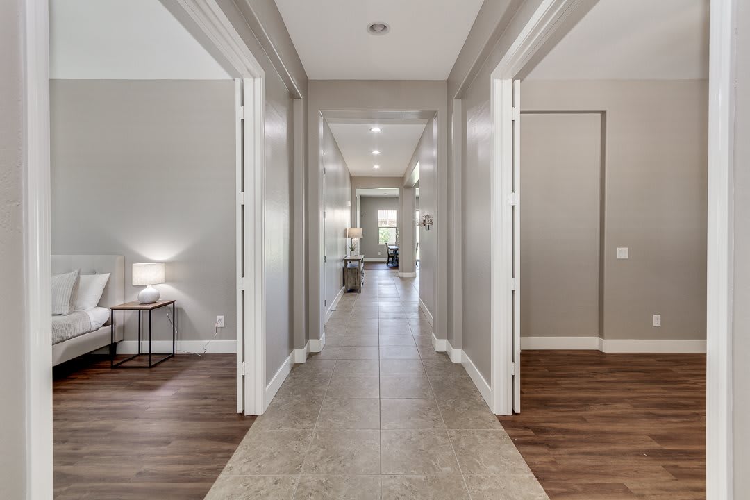 A modern hallway with elegant lighting and contrasting flooring.