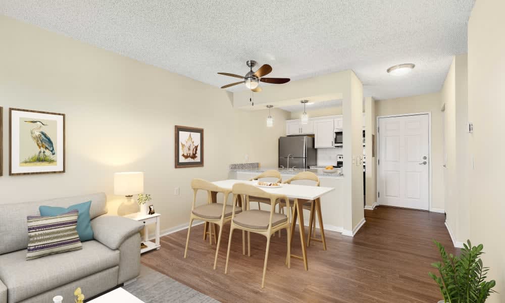A modern open-concept living and dining area with a kitchen, featuring wooden floors and stylish furniture.