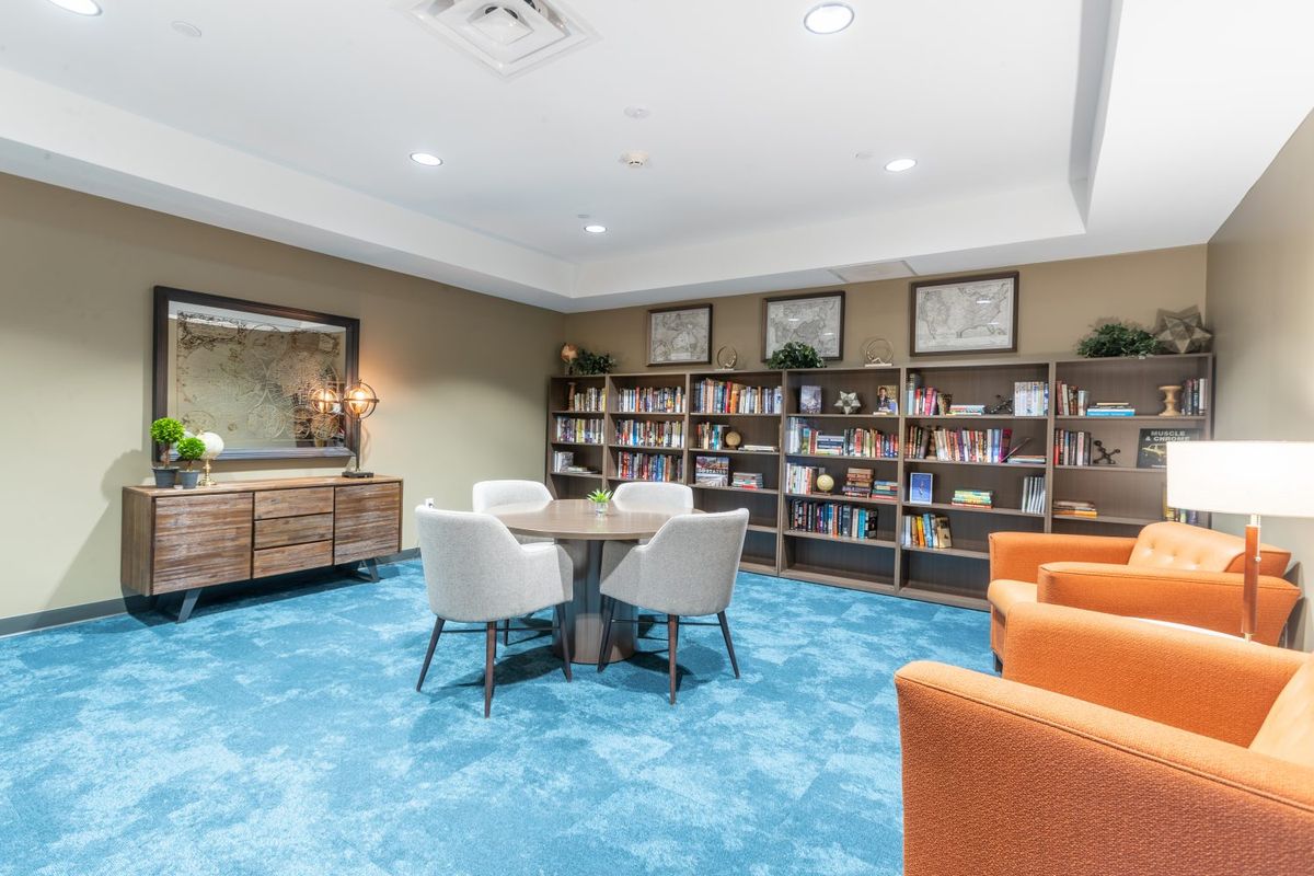 A modern library with bookshelves and a cozy seating area.