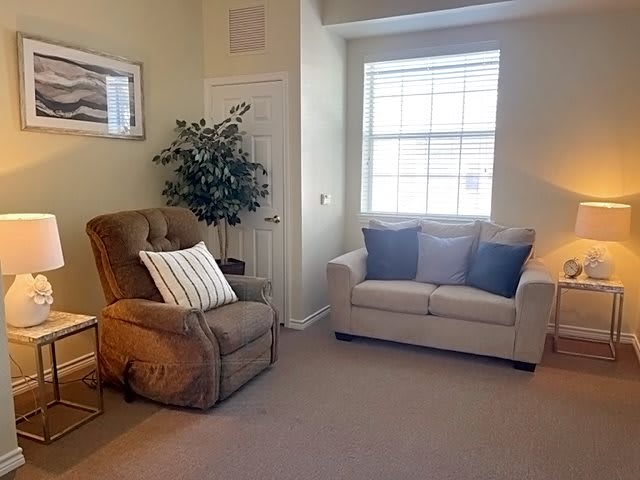 A cozy living room with a sofa, armchair, and decorative items.