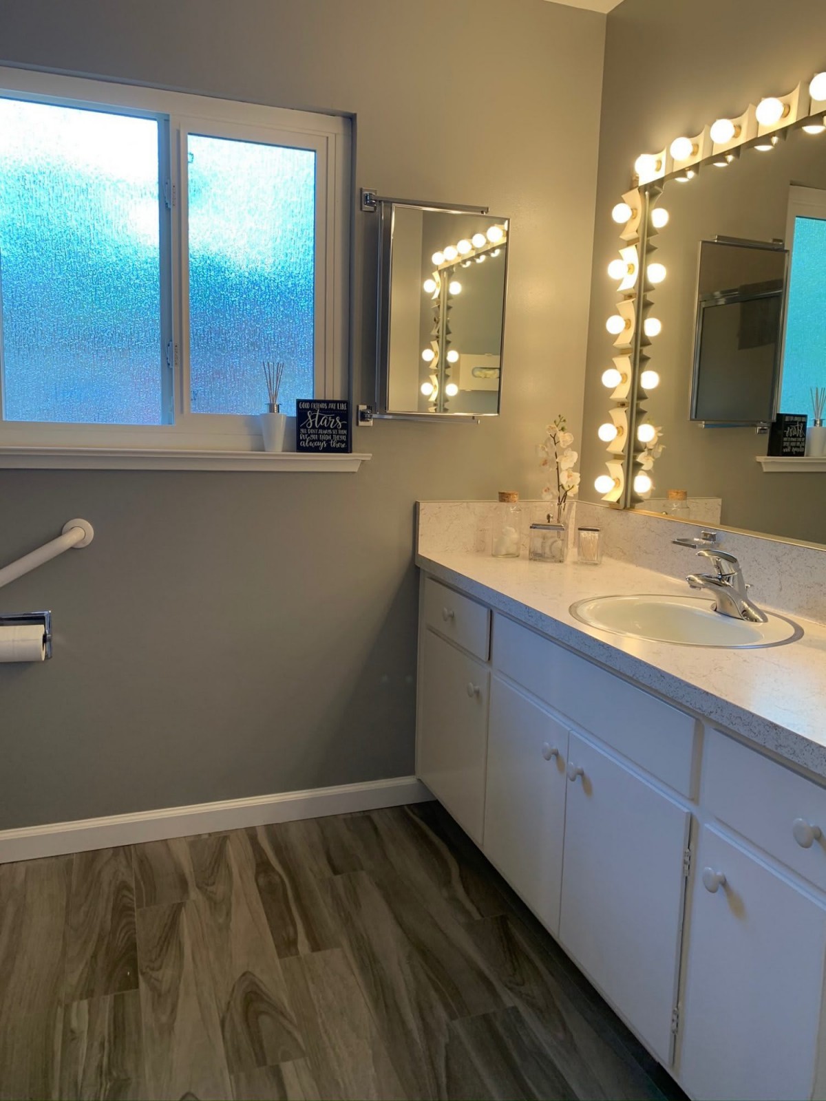 A modern bathroom with a well-lit vanity and a large mirror.