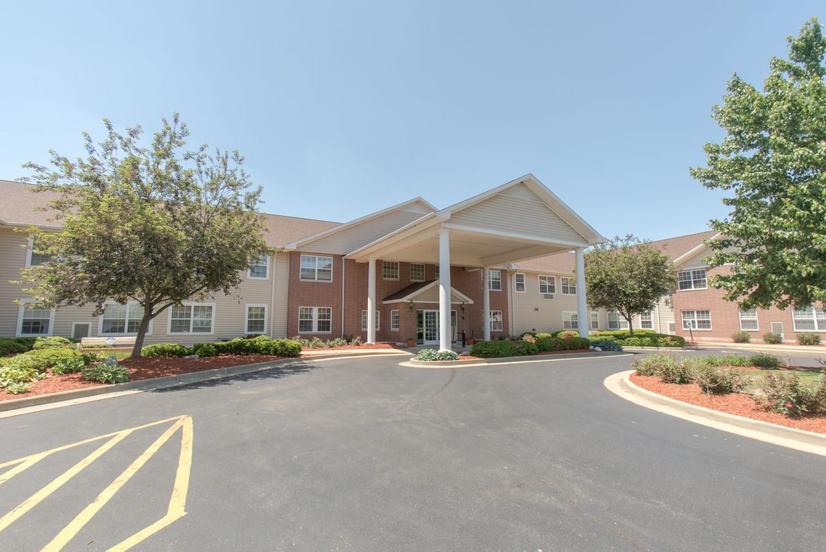 A two-story building with an entrance canopy and surrounding landscaping.