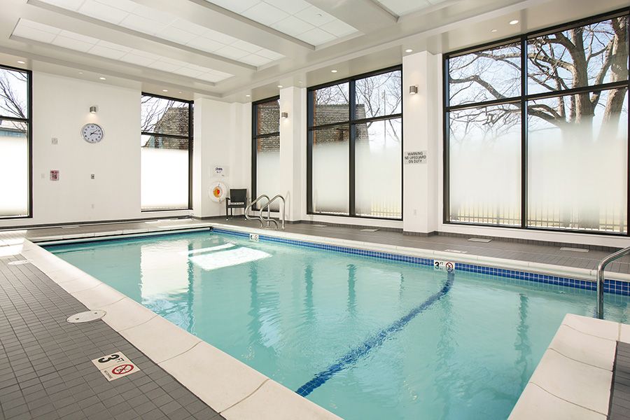 A serene indoor swimming pool with large windows and a clean, modern design.
