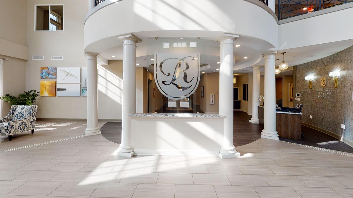 A bright and elegant lobby entrance with columns and a decorative emblem.