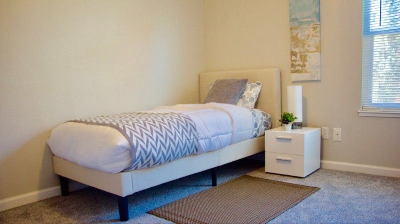 A minimalist bedroom with a single bed and nightstand.