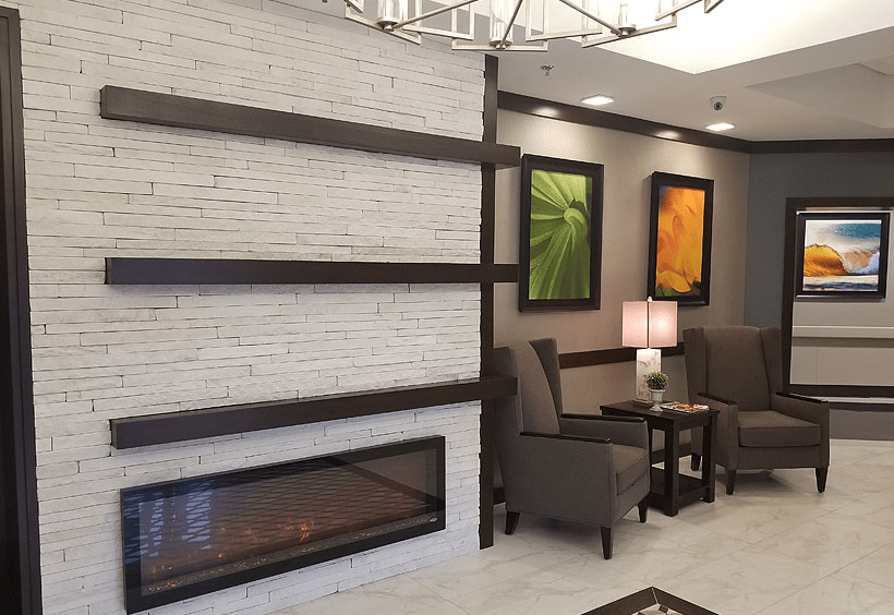 A modern lobby with a fireplace, seating area, and abstract artwork.