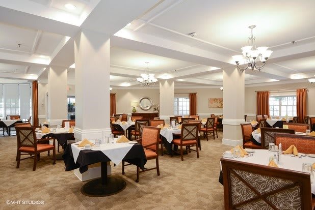 A spacious and elegantly decorated dining room with tables and chairs set for service.