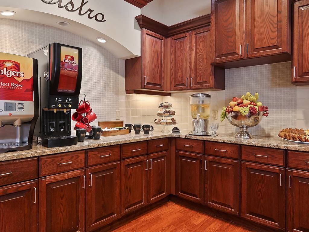 A cozy kitchen corner with wooden cabinets, a countertop beverage station, and elegant decor.