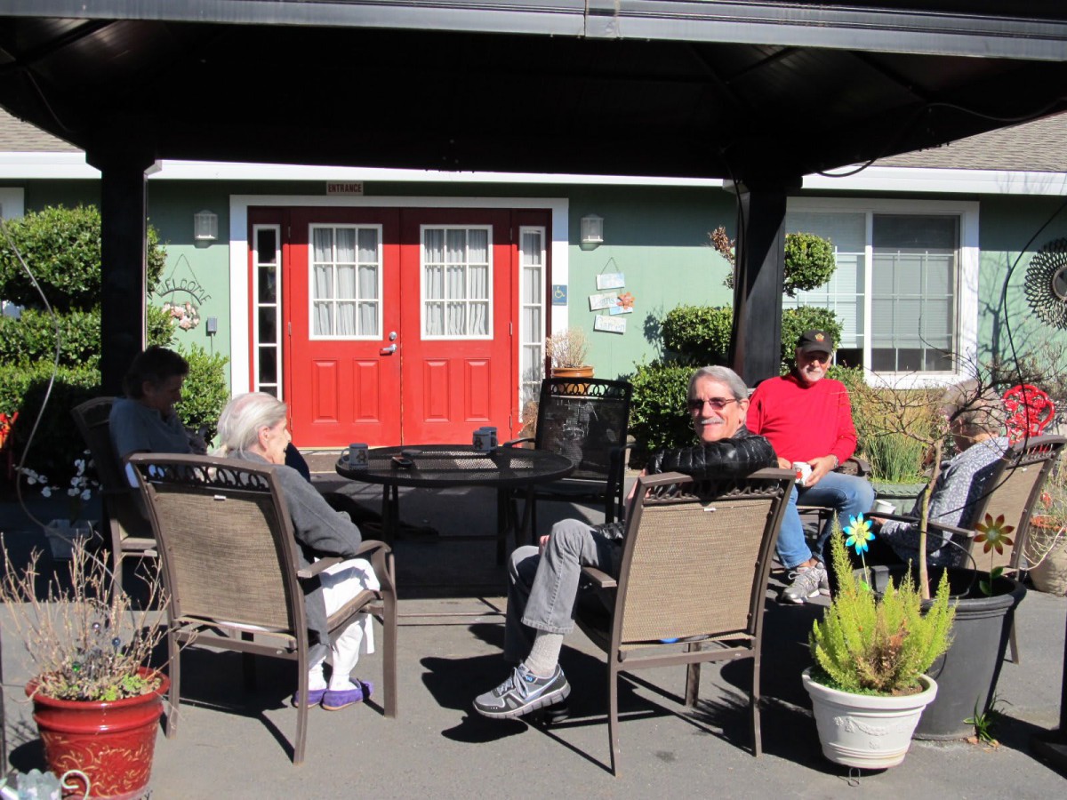 A group of people relaxing and socializing in an outdoor garden area.
