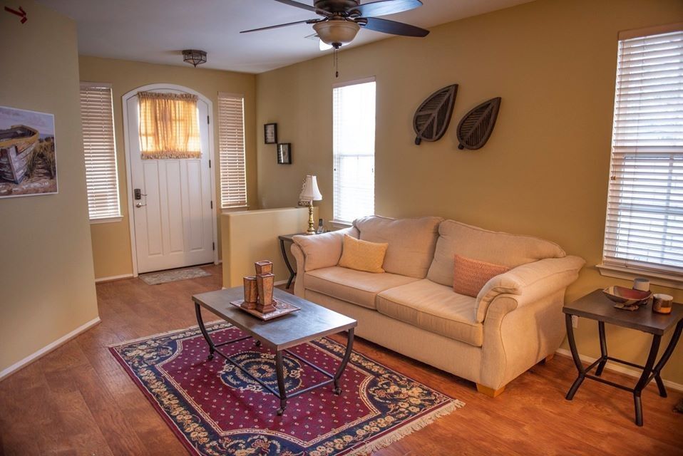 A cozy living room with a beige sofa, wooden coffee table, and a patterned rug.