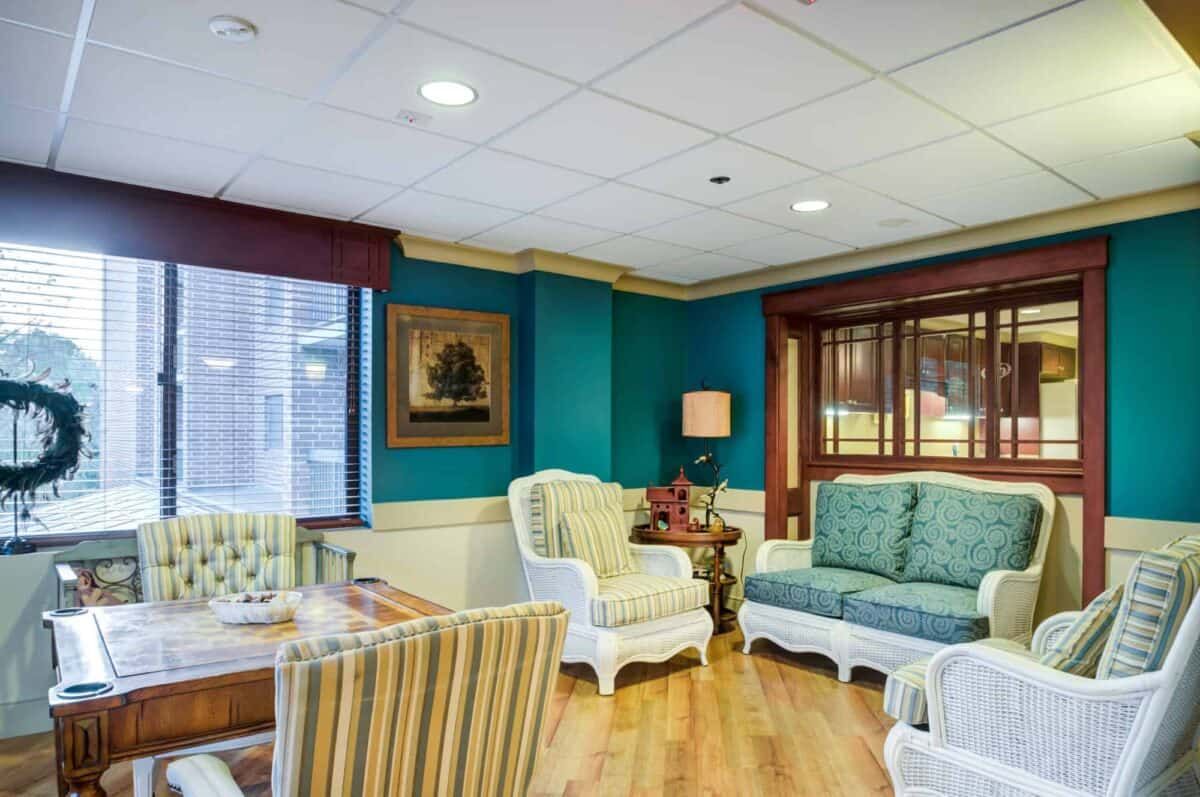 A cozy living room with elegant furniture, vibrant blue walls, and warm wooden flooring.