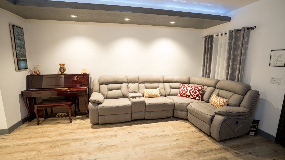 A cozy living room with a modern sectional sofa and wooden flooring.