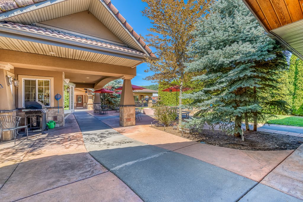 A sunny day at a residential house with a driveway and well-maintained landscaping.