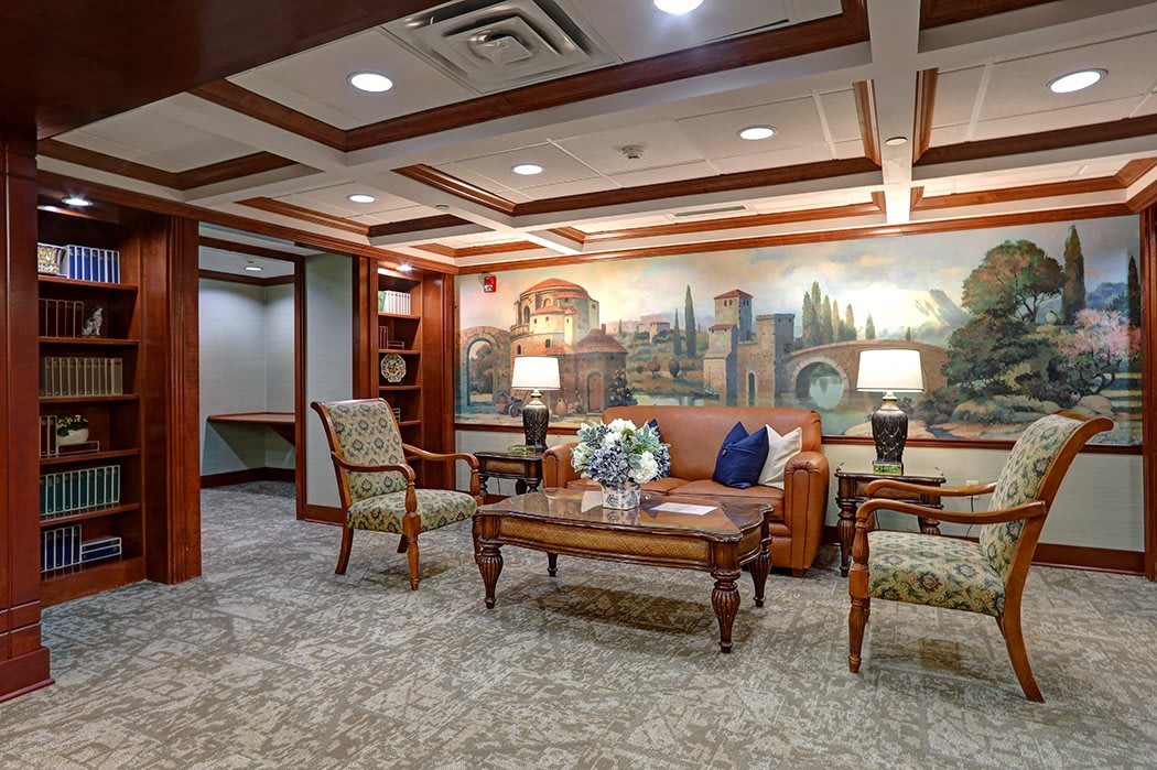 A traditionally styled lobby with comfortable seating and a decorative mural.