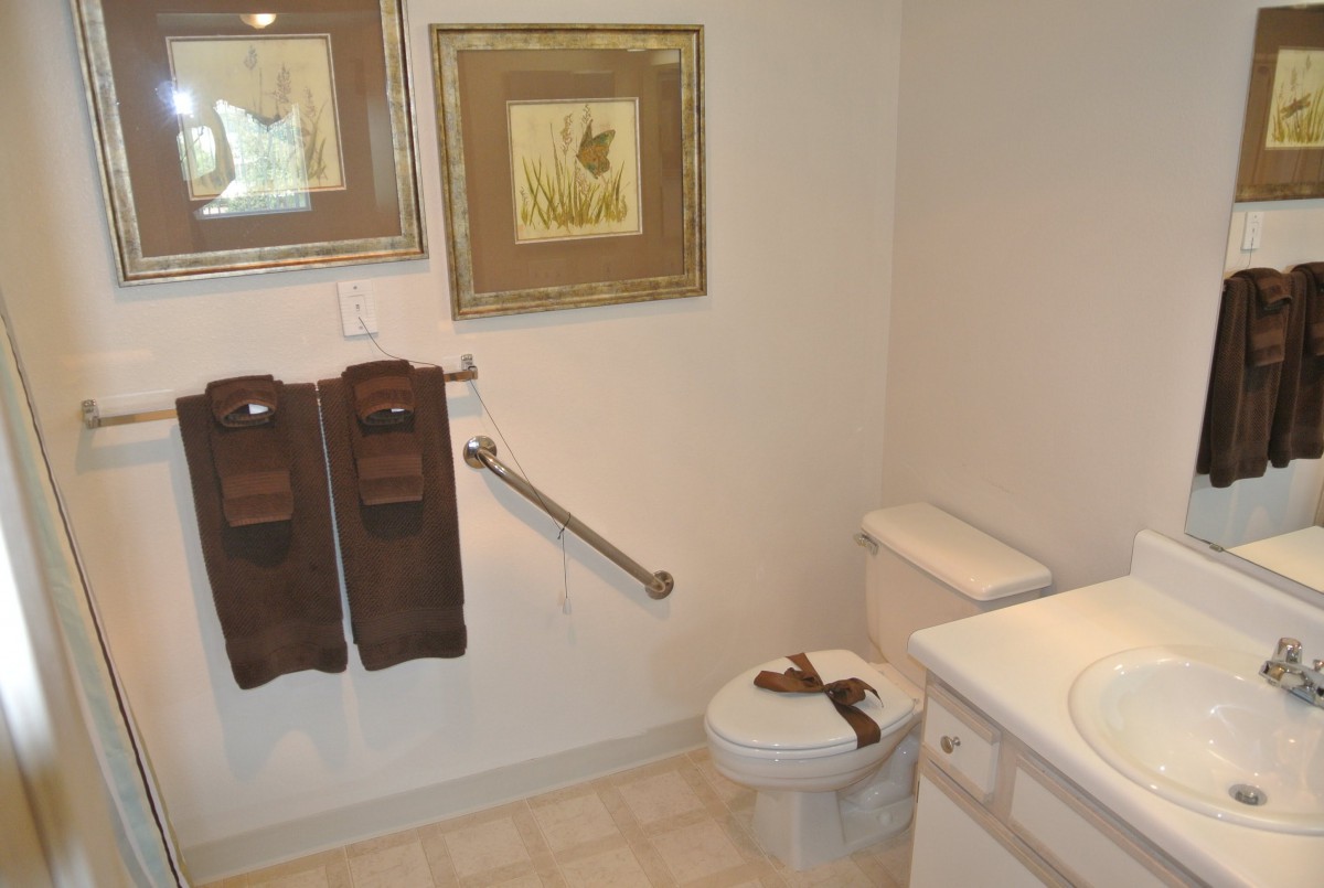 A well-decorated bathroom with a toilet, sink, and wall art.