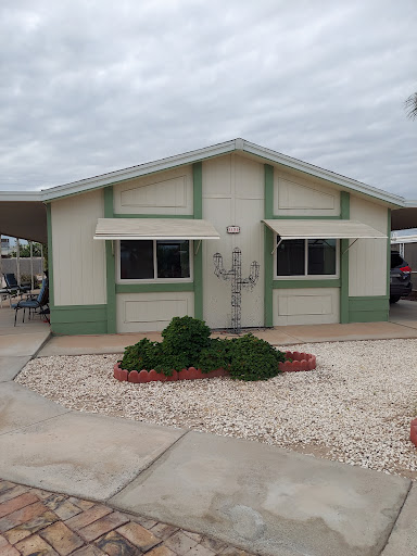 A charming residential house with a well-maintained front yard under a cloudy sky.