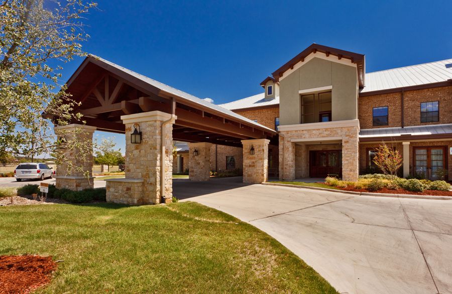 A modern residential building with a covered entrance and well-maintained landscaping.
