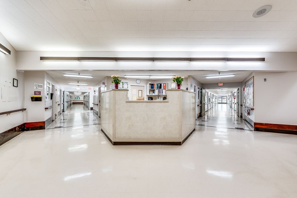 A clean hospital corridor with a central reception desk.