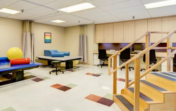 A modern physical therapy room equipped with exercise tools and rehabilitation stations.