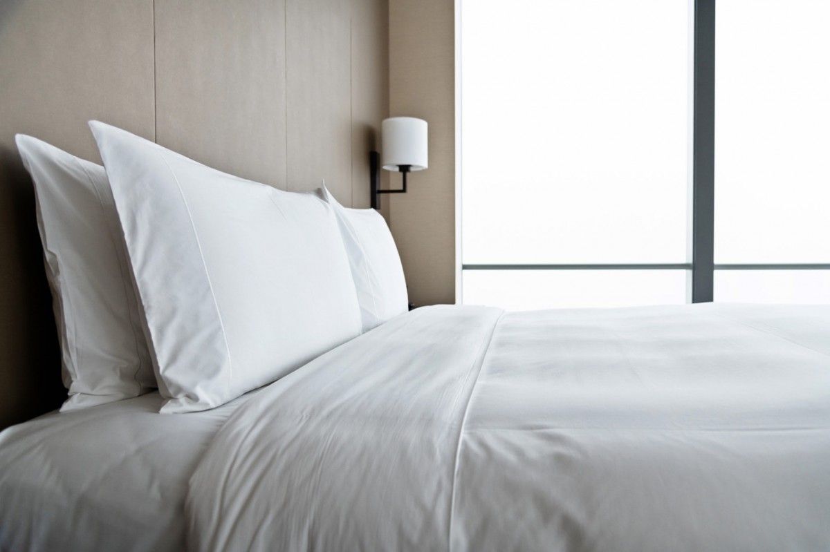 A minimalist bedroom with crisp white sheets and a modern design.