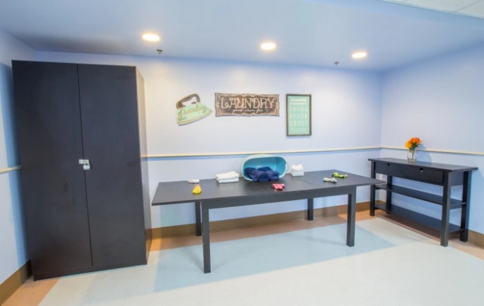 A minimalist office space featuring a table with various items, and artwork on the wall.