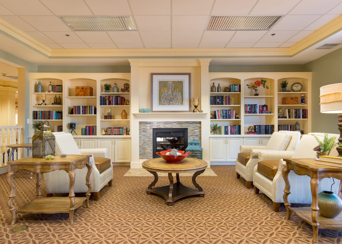 A cozy living room with elegant furniture and built-in bookshelves surrounding a fireplace.