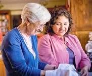 Two women engaged in a friendly conversation indoors.