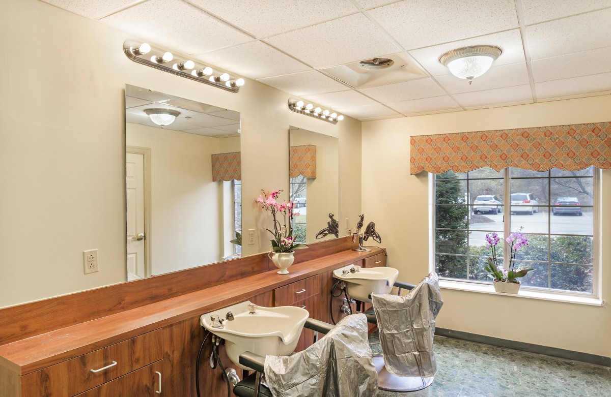 A well-lit hair salon interior with chairs and sinks.