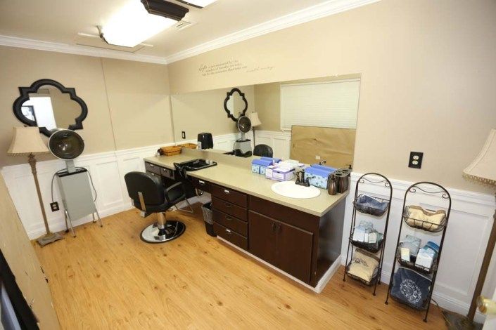 Interior of a modern barber shop with styling station and mirror.