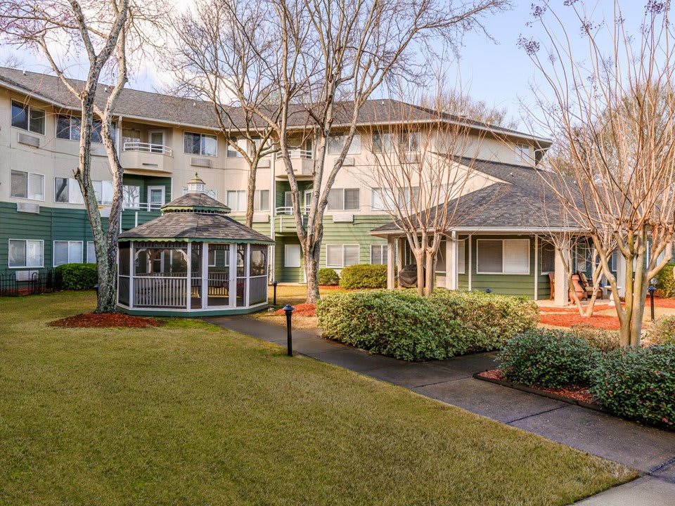 A view of an apartment complex with a landscaped garden and gazebo.
