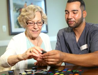 A caregiver assisting an elderly person with a task.