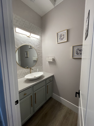 A modern bathroom featuring a stylish round mirror, sleek sink, and contemporary decor.