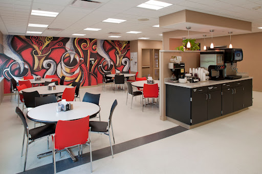 A modern cafe interior featuring colorful artwork and contemporary furniture.