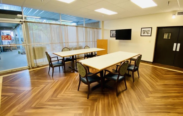 A well-lit conference room with tables and chairs arranged for a meeting.