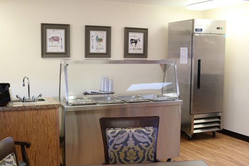 An interior view of a kitchen area featuring a food service counter and decorative artwork.